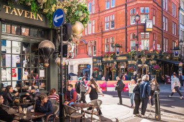 Londra, İngiltere - 25 Eylül 2025: Batı Yakası 'nda halk evi girişi ve dışarıda içen insanlar