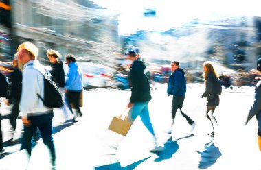 Güneşli bir günde Oxford Sirki 'nde dinamik bir sahne. Farklı yönlerde yürüyen bir kalabalık. Hareket bulanıklığı yoğun kavşağın hareketini ve enerjisini yakalıyor, postmodernizm titreşimi, canlı bir şekilde vurgulanıyor.