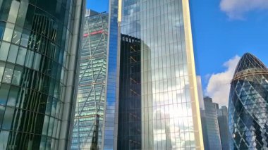 Londra, İngiltere - 3 Aralık 2025: Londra şehrinin modern gökdelenleri, uluslararası finans alanı. Pencerelerde günbatımı yansımaları.