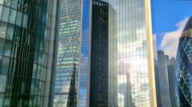 Londra, İngiltere - 3 Aralık 2025: Londra şehrinin modern gökdelenleri, uluslararası finans alanı. Pencerelerde günbatımı yansımaları.