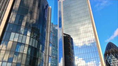 Londra, İngiltere - 3 Aralık 2025: Londra şehrinin modern gökdelenleri, uluslararası finans alanı. Pencerelerde günbatımı yansımaları.