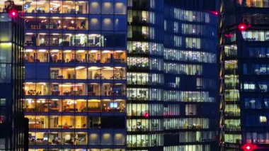 Londra, İngiltere - 3 Aralık 2025: Ofis pencerelerinde, ofis bloklarında ve geç saatlere kadar çalışanlar