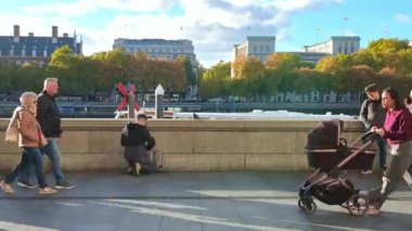 Londra, İngiltere - 2 Kasım 2025: Günbatımında Big Ben ve parlamento binalarında zaman kaybı. Thames nehrinin kıyısında bir sürü insan yürüyor.