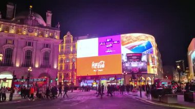 Londra, İngiltere - 25 Ekim 2025: Zaman atlamalı Piccadilly Sirki, kalabalık kavşağı geçiyor. Sokaklar trafikten geçilmiyor. Aralarında çok sayıda araba ve çift katlı ikonik otobüsler de var..