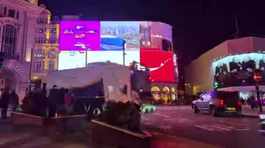 Londra, İngiltere - 25 Ekim 2025: Zaman atlamalı Piccadilly Sirki, kalabalık kavşağı geçiyor. Sokaklar trafikten geçilmiyor. Aralarında çok sayıda araba ve çift katlı ikonik otobüsler de var..