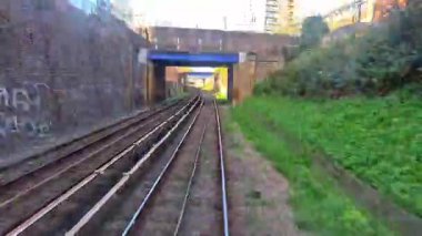 Londra, İngiltere - 27 Ekim 2025: DLR treniyle gün batımında limandan istasyona seyahat