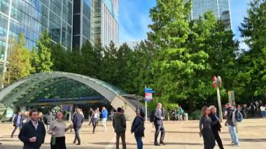 Londra, İngiltere - 23 Ekim 2025 Canary Wharf Meydanı, ofis binaları ve kurumsal gökdelenler. Banka caddesinde yürüyen insanlar, yolda koşan otobüsler ve taksiler.