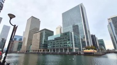 Londra, İngiltere - 7 Ekim 2025: Modern gökdelenler ve deniz kenarında yürüyen insanlar, Canary Wharf