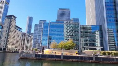 Londra, İngiltere - 7 Ekim 2025: Modern gökdelenler ve deniz kenarında yürüyen insanlar, Canary Wharf