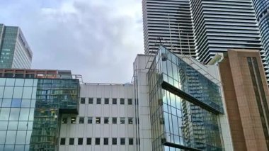 Londra, İngiltere - 7 Ekim 2025: Modern gökdelenler ve deniz kenarında yürüyen insanlar, Canary Wharf