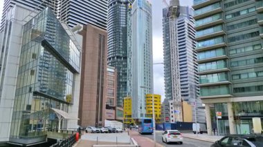 Londra, İngiltere - 7 Ekim 2025: Modern gökdelenler ve deniz kenarında yürüyen insanlar, Canary Wharf