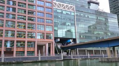 Londra, İngiltere - 7 Ekim 2025: Modern gökdelenler ve deniz kenarında yürüyen insanlar, Canary Wharf