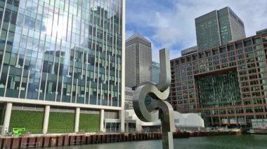 Londra, İngiltere - 7 Ekim 2025: Modern gökdelenler ve deniz kenarında yürüyen insanlar, Canary Wharf