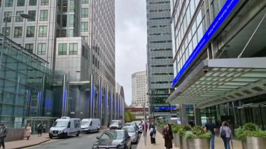 Londra, İngiltere - 23 Ekim 2025 Canary Wharf Meydanı, ofis binası, kurumsal gökdelenler, bankalar. İnsanlar Bank caddesinde yürüyor, otobüsler yolda koşuyor. Modern yoğun iş hayatı