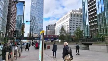 Londra İngiltere - 31 Ekim 2025: Canary Wharf bankacılık ve iş alanında çalışan DLR treni, iç rıhtım manzaralı. Ofis ve şirket binaları
