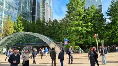 Londra, İngiltere - 23 Ekim 2025 Canary Wharf Meydanı, ofis binası, kurumsal gökdelenler, bankalar. İnsanlar Bank caddesinde yürüyor, otobüsler yolda koşuyor. Modern yoğun iş hayatı