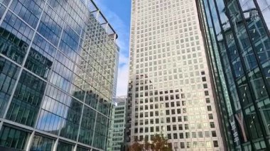 Londra, İngiltere - 23 Ekim 2025 Canary Wharf Meydanı, ofis binası, kurumsal gökdelenler, bankalar. İnsanlar Bank caddesinde yürüyor, otobüsler yolda koşuyor. Modern yoğun iş hayatı