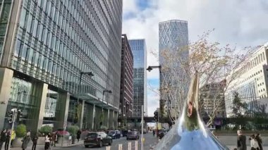 Londra, İngiltere - 23 Ekim 2025 Canary Wharf Meydanı, ofis binası, kurumsal gökdelenler, bankalar. İnsanlar Bank caddesinde yürüyor, otobüsler yolda koşuyor. Modern yoğun iş hayatı