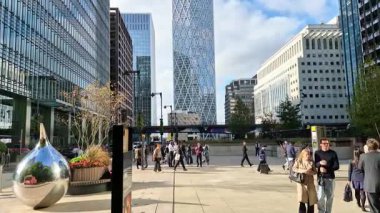 Londra, İngiltere - 23 Ekim 2025 Canary Wharf Meydanı, ofis binası, kurumsal gökdelenler, bankalar. İnsanlar Bank caddesinde yürüyor, otobüsler yolda koşuyor. Modern yoğun iş hayatı