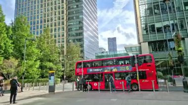 Londra, İngiltere - 23 Ekim 2025 Canary Wharf Meydanı, ofis binası, kurumsal gökdelenler, bankalar. İnsanlar Bank caddesinde yürüyor, otobüsler yolda koşuyor. Modern yoğun iş hayatı