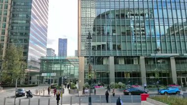 Londra, İngiltere - 23 Ekim 2025 Canary Wharf Meydanı, ofis binası, kurumsal gökdelenler, bankalar. İnsanlar Bank caddesinde yürüyor, otobüsler yolda koşuyor. Modern yoğun iş hayatı