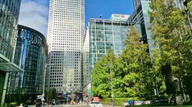 Londra, İngiltere - 23 Ekim 2025 Canary Wharf Meydanı, ofis binası, kurumsal gökdelenler, bankalar. İnsanlar Bank caddesinde yürüyor, otobüsler yolda koşuyor. Modern yoğun iş hayatı