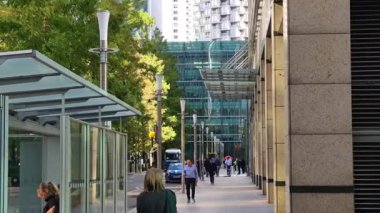 Londra, İngiltere - 23 Ekim 2025 Canary Wharf Meydanı, ofis binası, kurumsal gökdelenler, bankalar. İnsanlar Bank caddesinde yürüyor, otobüsler yolda koşuyor. Modern yoğun iş hayatı