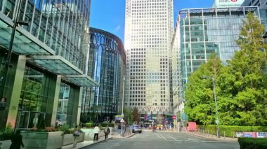 Londra, İngiltere - 23 Ekim 2025 Canary Wharf Meydanı, ofis binası, kurumsal gökdelenler, bankalar. İnsanlar Bank caddesinde yürüyor, otobüsler yolda koşuyor. Modern yoğun iş hayatı