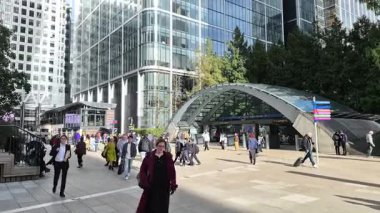 Londra, İngiltere - 23 Ekim 2025 Canary Wharf Meydanı, ofis binası, kurumsal gökdelenler, bankalar. İnsanlar Bank caddesinde yürüyor, otobüsler yolda koşuyor. Modern yoğun iş hayatı