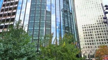Londra, İngiltere - 23 Ekim 2025 Canary Wharf Meydanı, ofis binası, kurumsal gökdelenler, bankalar. İnsanlar Bank caddesinde yürüyor, otobüsler yolda koşuyor. Modern yoğun iş hayatı
