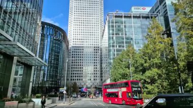 Londra, İngiltere - 23 Ekim 2025 Canary Wharf Meydanı, ofis binası, kurumsal gökdelenler, bankalar. İnsanlar Bank caddesinde yürüyor, otobüsler yolda koşuyor. Modern yoğun iş hayatı