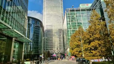 Londra, İngiltere - 23 Ekim 2025 Canary Wharf Meydanı, ofis binası, kurumsal gökdelenler, bankalar. İnsanlar Bank caddesinde yürüyor, otobüsler yolda koşuyor. Modern yoğun iş hayatı