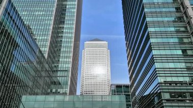 Londra, İngiltere - 23 Ekim 2025 Canary Wharf Meydanı, ofis binası, kurumsal gökdelenler, bankalar. İnsanlar Bank caddesinde yürüyor, otobüsler yolda koşuyor. Modern yoğun iş hayatı
