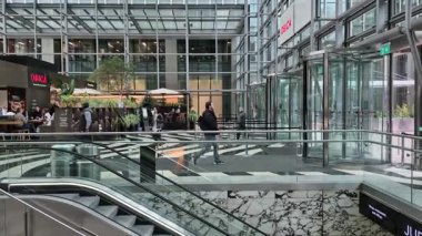 Londra, İngiltere - 7 Ekim 2025: Canary Wharf 'taki modern gökdelenin lobisinden çıkan insanlar