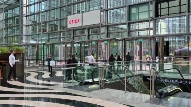 Londra, İngiltere - 7 Ekim 2025: Canary Wharf 'taki modern gökdelenin lobisinden çıkan insanlar