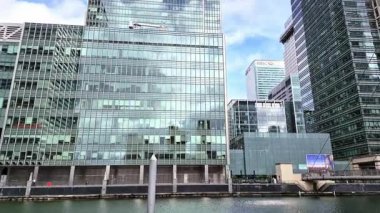 Londra, İngiltere - 7 Ekim 2025: Modern gökdelenler ve deniz kenarında yürüyen insanlar, Canary Wharf