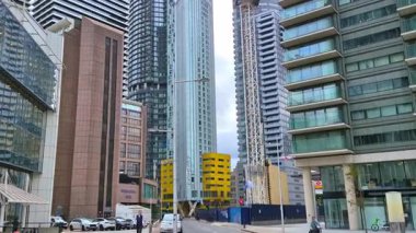 Londra, İngiltere - 7 Ekim 2025: Modern gökdelenler ve deniz kenarında yürüyen insanlar, Canary Wharf