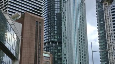 Londra, İngiltere - 7 Ekim 2025: Modern gökdelenler ve deniz kenarında yürüyen insanlar, Canary Wharf