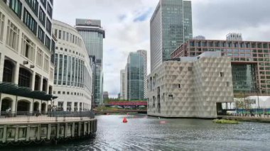 Londra, İngiltere - 23 Ekim 2025: Canary Wharf, Bank caddesi, ofis binaları, cam gökdelenler, suya park ve yürüyen insanlar orta rıhtım manzarası