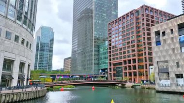Londra, İngiltere - 23 Ekim 2025: Canary Wharf, Bank caddesi, ofis binaları, cam gökdelenler, suya park ve yürüyen insanlar orta rıhtım manzarası