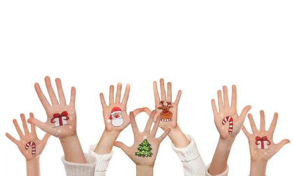 Símbolos de Natal pintados nas mãos de crianças. Papai Noel, boneco de neve, árvore de Natal, caixa de presente, renas etc — Fotografia de Stock