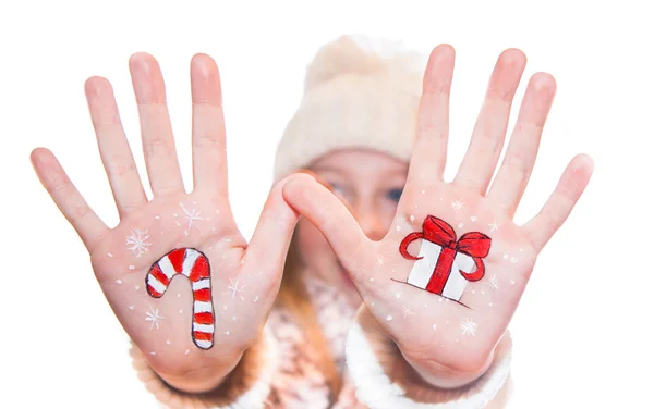 Glückliches Mädchen zeigt bemalte Weihnachtssymbole auf ihren Händen. — Stockfoto