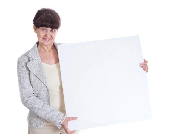 Mature woman leaning on white banner. Portrait against of white background — Stock Photo, Image