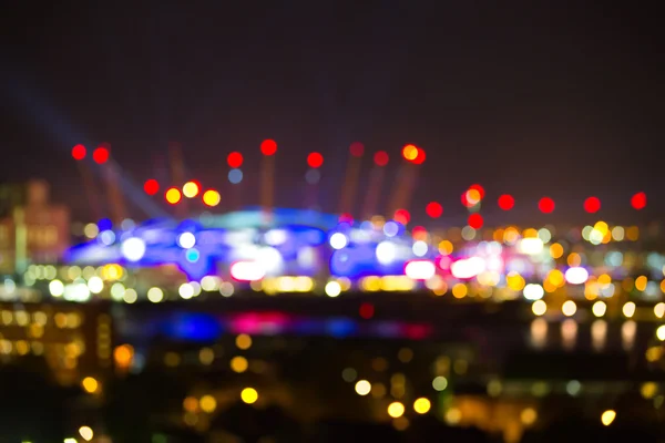 London Arena unter Lichteinfall. Lichter der Stadt verschwimmen Hintergrund. — Stockfoto