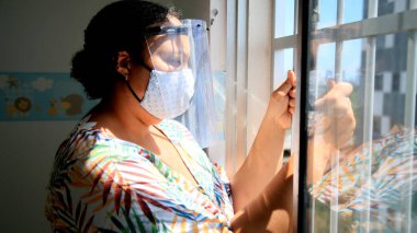  Salvador, Bahia, Brezilya - 6 Aralık 2020: Salvador şehrinde kadın akrilik yüz kalkanı ve koronavirüse karşı koruyucu maske takıyor.