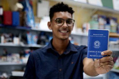 mata de sao joao, bahia, brazil - october 1, 2020: young man of black ethnicity displays a work and social security card, a necessary document for formalizing the registration of work in Brazil. *** Local Caption *** clipart