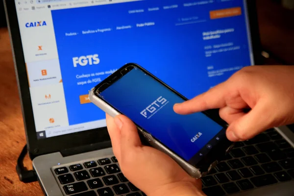 Salvador, Bahia, Brezilya - 8 Aralık 2020: cep telefonlu kişi Salvador şehrindeki Caixa Economica Federal web sitesinden FGTS sayfasına erişmeye çalışıyor.