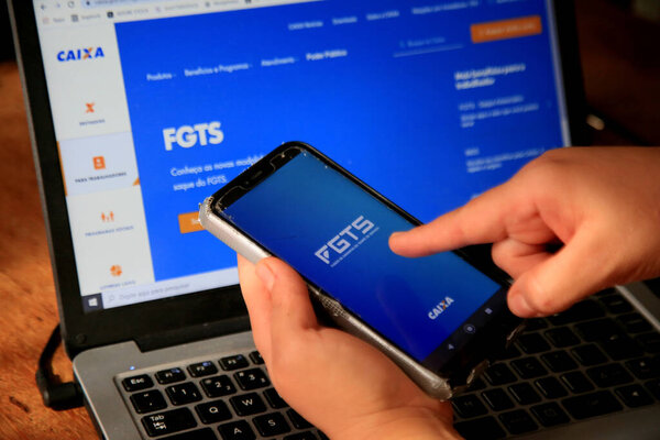 salvador, bahia, brazil - december 8, 2020: person with cell phone trying to access the FGTS page on the Caixa Economica Federal website in the city of Salvador.