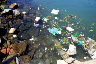 Salvador, Bahia, Brezilya - 11 Aralık 2020: Salvador şehrindeki Feira de Sao Joaquim limanındaki botların yakınında plastik ambalaj ve çöplerin imhası.