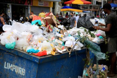 Salvador, Bahia, Brezilya - 16 Aralık 2020: Adam Salvador şehir merkezinde geri dönüşüm için malzeme aramak üzere çöp konteynırını teslim eder. * * * Yerel altyazı * *